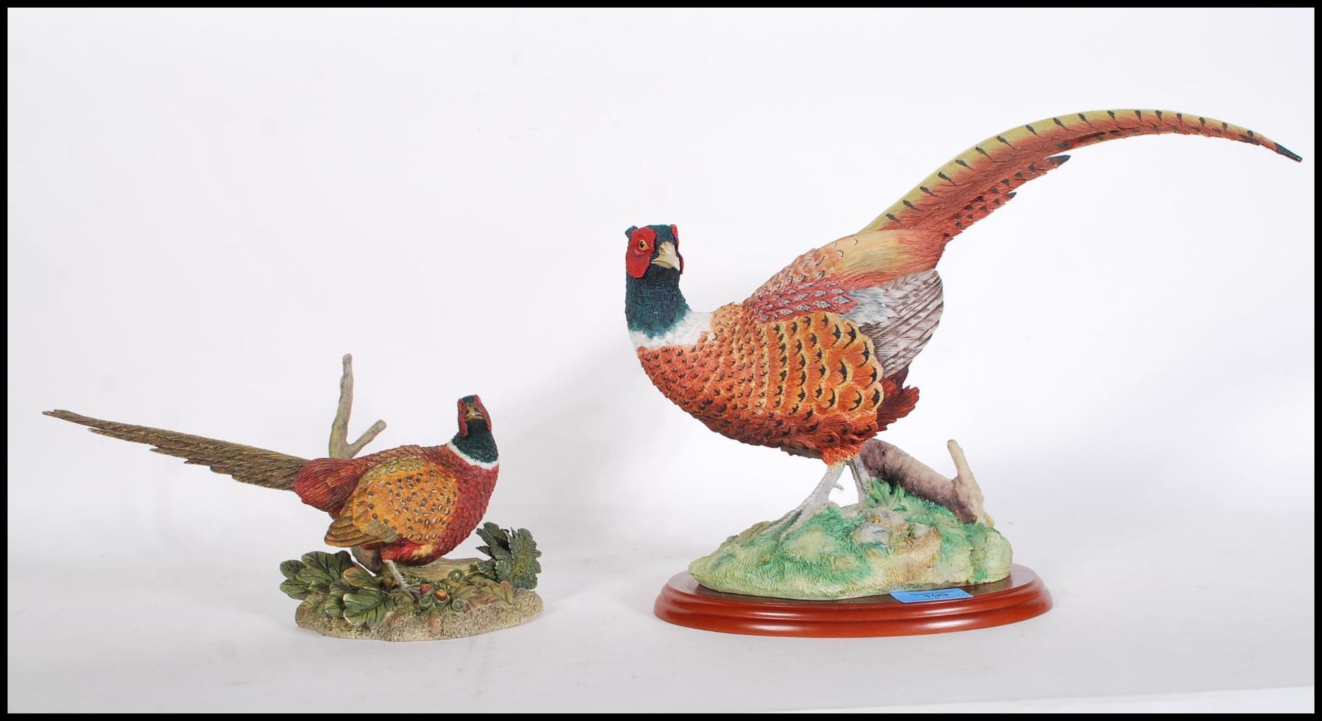 A large ceramic Border Fine Arts pheasant figurine no. A0659 raised on a wooden base together with