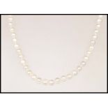 A row of cultured pearls ( Pearl necklace )  compl
