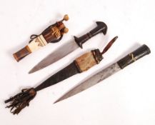 TWO EARLY 20TH CENTURY AFRICAN LEATHER WORKED ARM DAGGERS