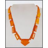 A vintage Art Deco amber bakelite necklace with yellow metal clasp. Large axe shaped panels with