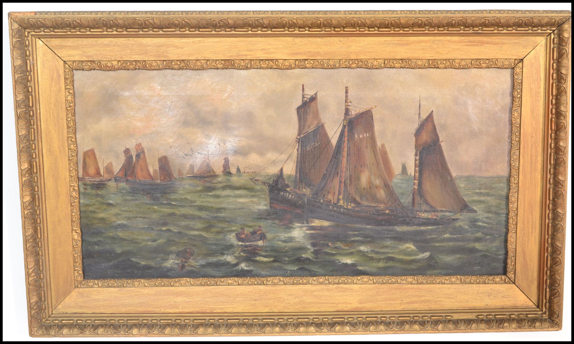 A early 20th Century oil on canvas of a seascape having Dutch sailing boats with figures in a rowing