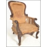 A 19th Century Victorian mahogany framed armchair of spoon back form with scroll arms with carved