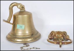 A 20th Century large brass ships style bell with wall hanging bracket attached together with a