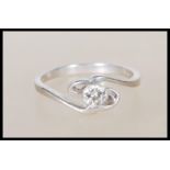 A 950 platinum solitaire diamond ring having an openwork swirl mount set with a single diamond