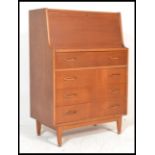 A retro 20th Century teak wood bureau / desk, full front with fully appointed interior over a run of