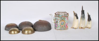 A Chinese famille verte teapot being hand painted with floral and narrative panels bound handles