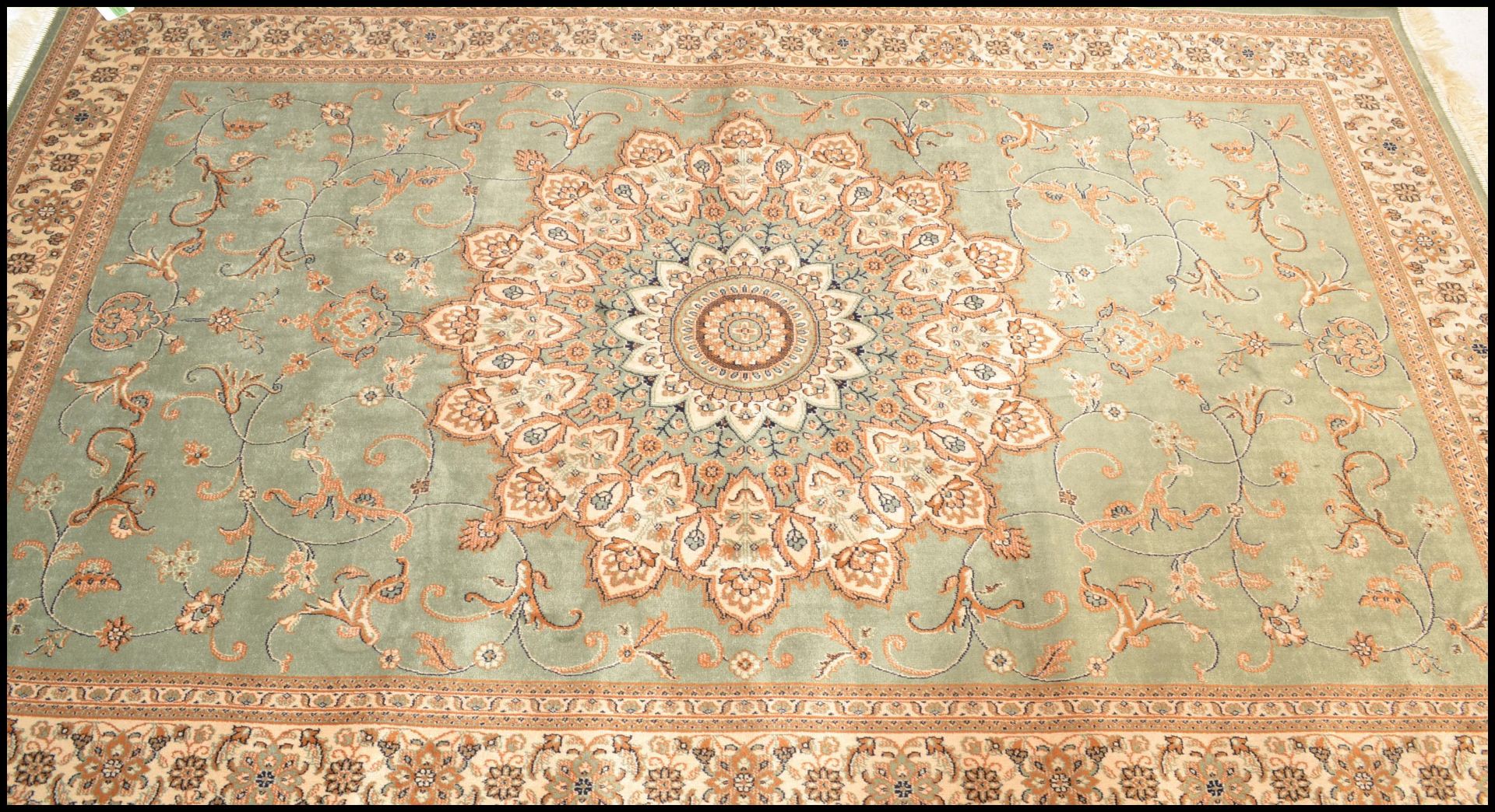 A large Persian floor carpet Keshan rug having a green ground with geometric borders and central