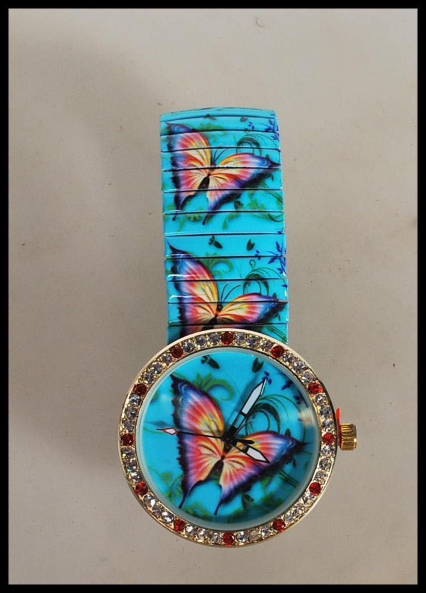 A ladies wrist watch having butterfly decoration to the face and expanding watch bracelet with the