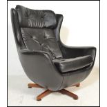 A 1970's retro vintage Parker Knoll statesman swivel and tilt action egg chair having a black