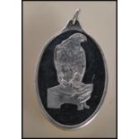 A fine 999 Suisse one ounce fine silver ingot pendant of oval form having an embossed eagle to