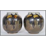 A pair of early 20th Century Royal Doulton ceramic vases of globular form having hand painted