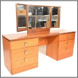 A vintage retro 20th Century teak wood kneehole dressing table with a twin bank of three
