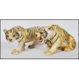 A pair of 20th Century cast resin figurines of tigers having hand painted features to include one