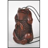 A 20th Century carved hardwood oriental toggle of large proportions in the form of a frog strung
