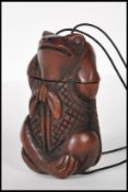 A 20th Century carved hardwood oriental toggle of large proportions in the form of a frog strung