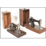 Two early 20th Century oak cased hand crank manual sewing machines,the first by Singer and the other