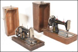 Two early 20th Century oak cased hand crank manual sewing machines,the first by Singer and the other