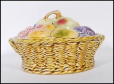 An early 20th Century ceramic Sarreguemines lidded pot modelled as a basket of fruit, the base