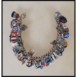 A vintage sterling silver souvenir / charm bracelet having a large number of silver enamelled