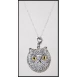 A silver pendant necklace in the form of a owl having glass eyes on a fine link silver chain.