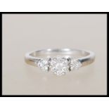 A hallmarked 9ct white gold ring set with a central cluster of white stones flanked by three further