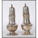 A pair of silver hallmarked table pepperettes by Zachariah Barraclough & Sons, raised on a round