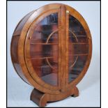 A 1930's Art Deco walnut china roundel display cabinet. The round circular cabinet with twin doors