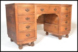 An Edwardian mahogany kneehole twin pedestal desk, the shallow inverted breakfront fitted with a