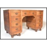 An Edwardian mahogany kneehole twin pedestal desk, the shallow inverted breakfront fitted with a