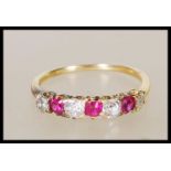 A stamped 18ct yellow gold ring having a decorative pierced mount set with diamonds and rubies.