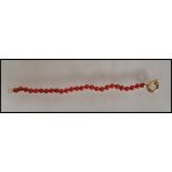 A Chinese 18ct gold and coral bracelet consisting of twenty six coral beads with a 18ct gold