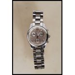 A contemporary ladies Michael Kors wrist watch having a round face with a silvered dial with baton