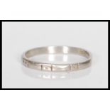 A stamped platinum band ring having engraved geometric decoration. Weight 2.4g. Size M.5.