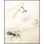A vintage retro mid 20th Century anglepoise desk lamp by Herbert Terry raised on a white round