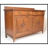 An early 20th Century Edwardian oak sideboard credenza, gallery back with flared top over two reeded