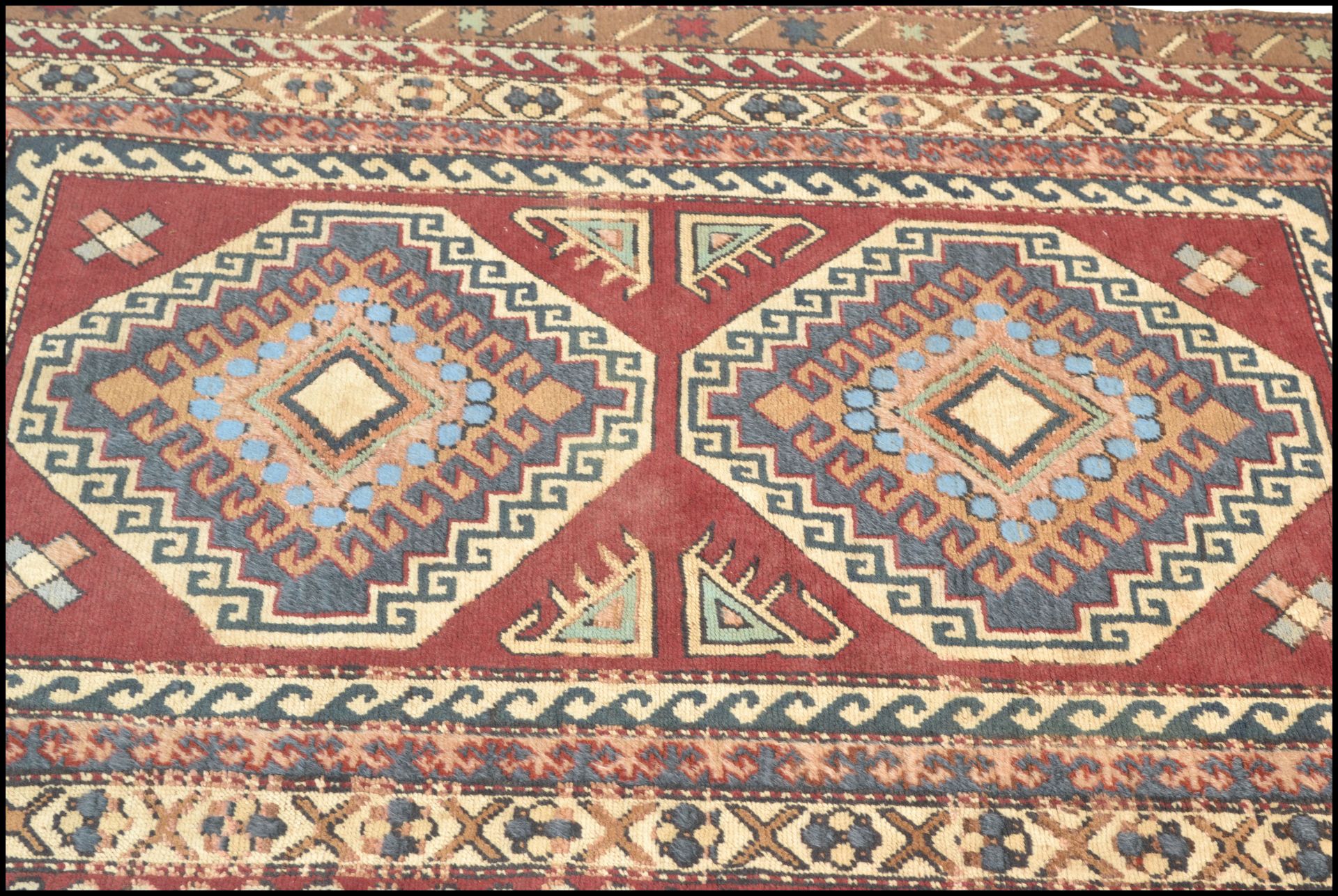 A vintage 20th Century Kazak hand knotted floor rug. Red ground, with stylised geometric borders and - Bild 2 aus 4