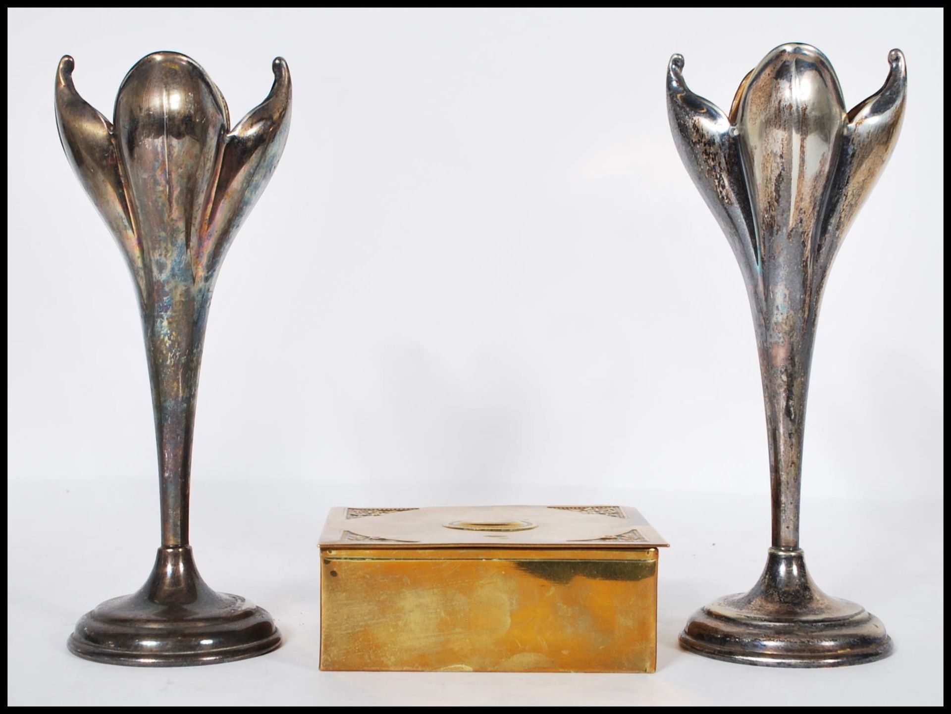 A pair of silver plated Art Nouveau mantelpiece spill vases in the form of opening flowers raised on