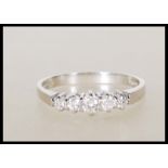 A hallmarked 18ct white gold ladies dress ring set with five graduating diamonds of approx 25