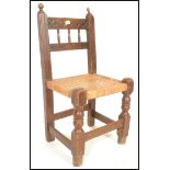 A 19th Century oak peg jointed Spanish chair for a child, carved gallery spindle back bordered by