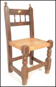 A 19th Century oak peg jointed Spanish chair for a child, carved gallery spindle back bordered by