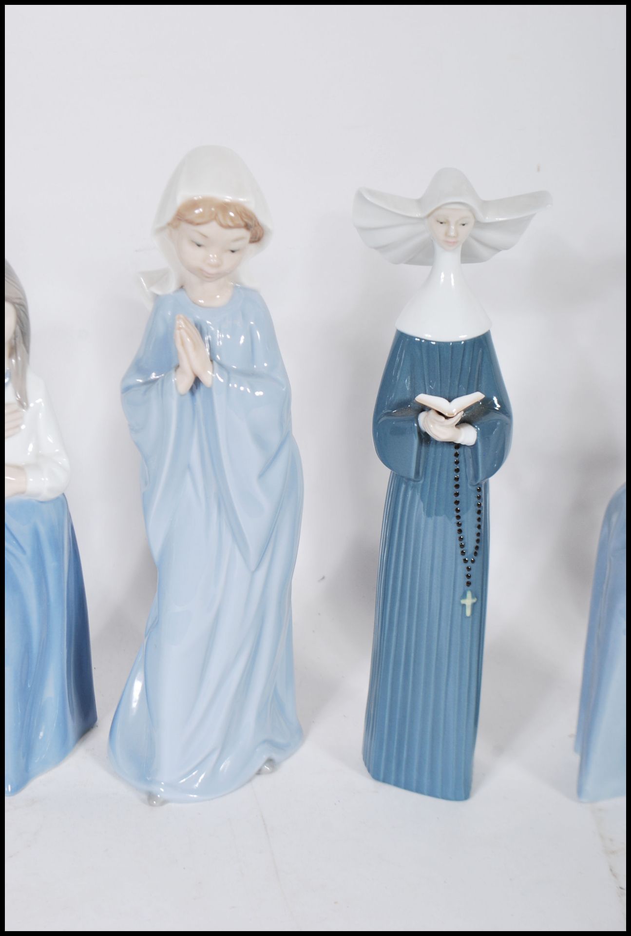 A collection of Nao and Lladro ceramic figurines to include a Lladro nun, a Lladro praying cherub, - Bild 3 aus 7