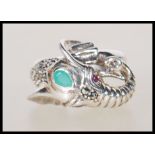 A stamped 925 silver ladies ring in the form of an elephant having ruby eyes with a emerald cabochon