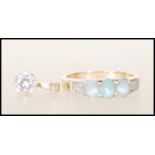 A hallmarked 9ct gold ladies dress ring set with three light blue stones with white accent stones to