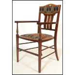 An early 20th Century Edwardian Arts and Crafts mahogany and satin inlaid elbow chair, the shaped