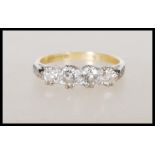 An 18ct yellow gold ring set with four diamonds having platinum shoulders having illusion set