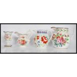 A group of three 19th Century Staffordshire jugs all having hand painted floral sprays to include