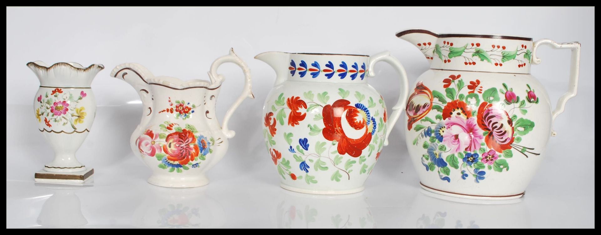 A group of three 19th Century Staffordshire jugs all having hand painted floral sprays to include