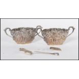 A pair of 19th Century silver hallmarked twin handled table salts, half gadrooned under decorative