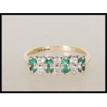 A 9ct gold English hallmarked ring set with two rows of alternate white and green stones. Hallmarked