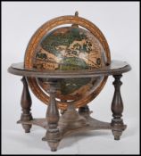 A 20th Century antique style desktop celestial globe raised on a gimbal stand with turned legs